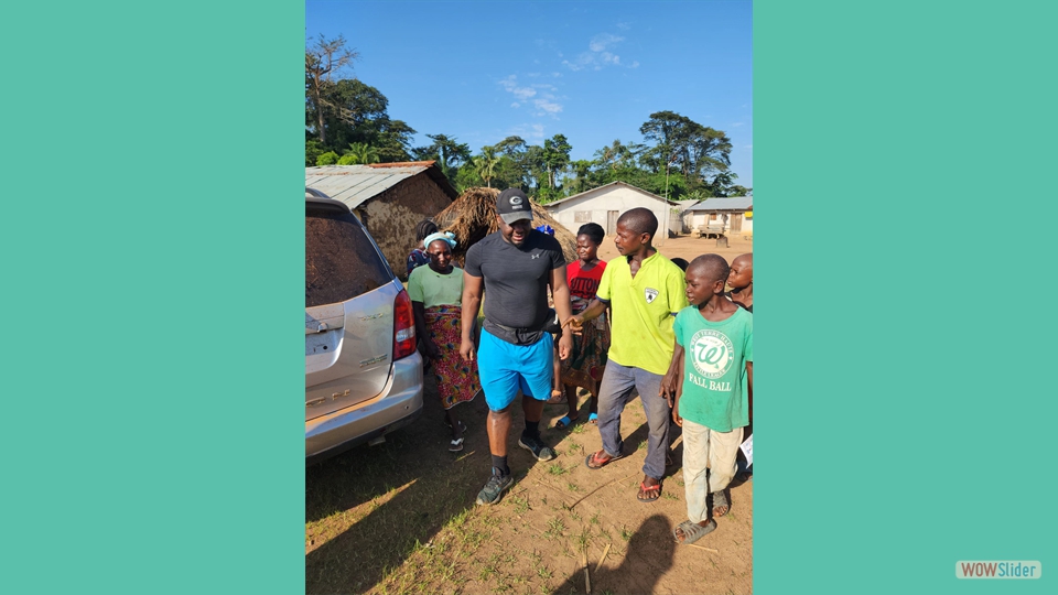 Some youths welcome Mr. Harrison Siakor, who was part of the renovation team in Gboawuta village.